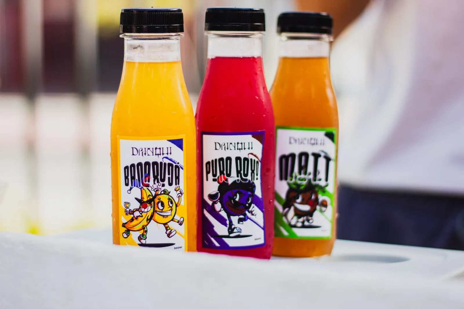 Garrafas dos drinks Banarujá, Puro Roxo e Matt lado a lado